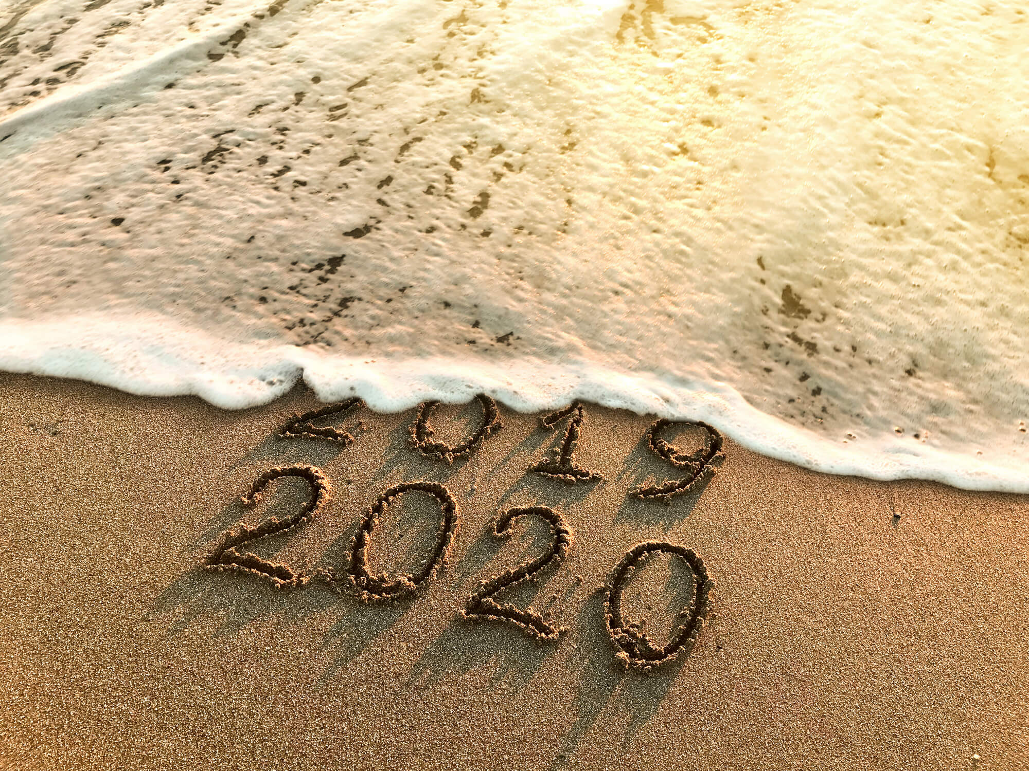 2019 and 2020 written in sand