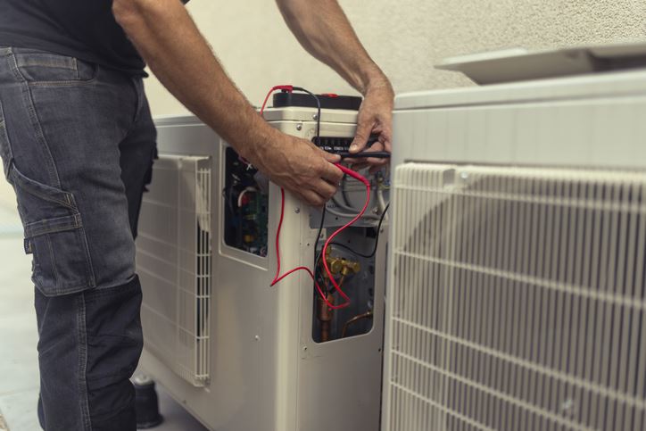 HVAC tech maintaining outdoor unit